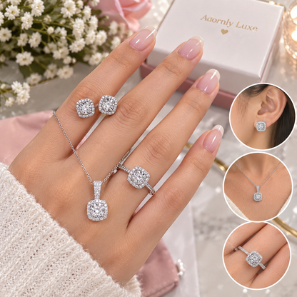 A jewelry set displayed on a hand, featuring a silver-toned pendant necklace, matching ring, and stud earrings with clear square-cut stones. The set is shown with a branded Adornly Luxe gift box, flowers, and three circular inset views demonstrating how the jewelry looks when worn.