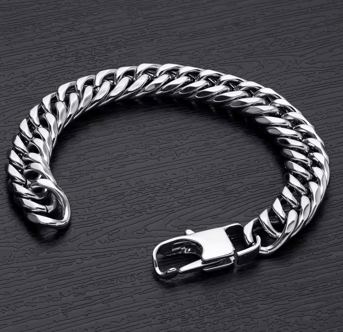 Silver chain bracelet on a dark textured surface